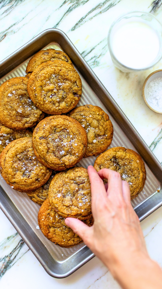 hand grabbing brown butter pumpkin chocolate chunk cookies